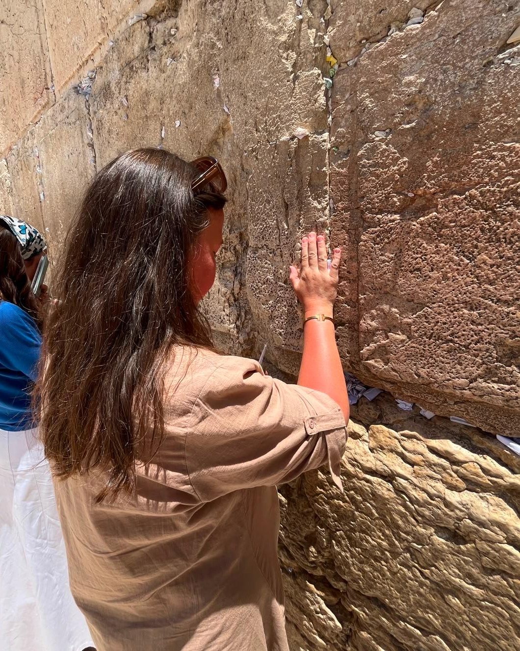 En kvinna ber med handen mot Västmuren i Jerusalem